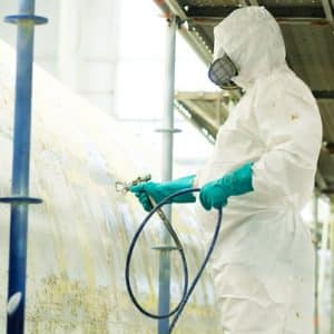 Employé industriel en train de pulvériser un produit contenant des diisocyanates